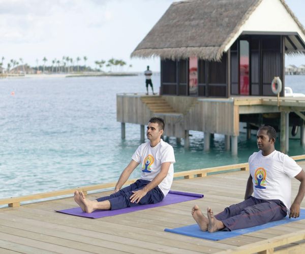 Person practicing breathing exercises outdoors during sunrise.